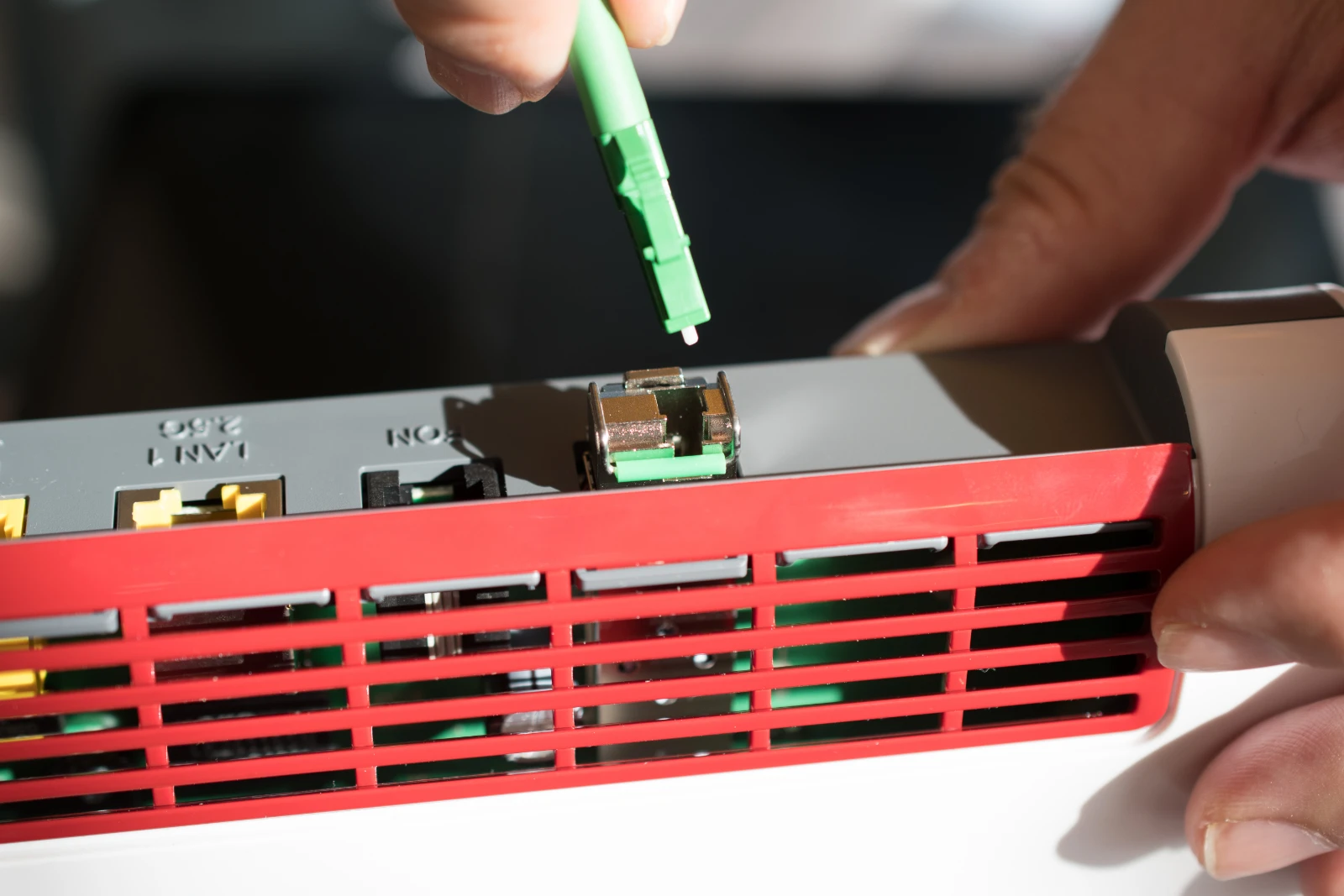 Ein Glasfaserkabel wird an einen Glasfaserrouter angeschlossen.